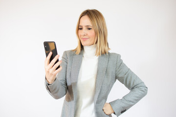 Portrait of a smiling elegant woman holding smartphone over white background