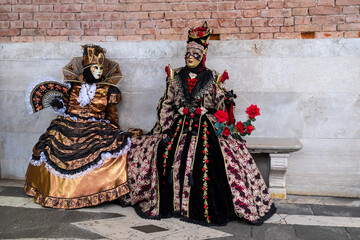 Fototapeta na wymiar Venice, Italy - February 17, 2020: An unidentified couple in a carnival costume in Piazza San Marco attends at the Carnival of Venice.