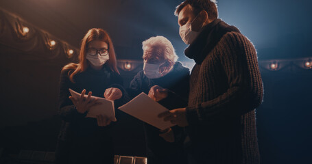 Elderly director supporting actors during quarrel scene