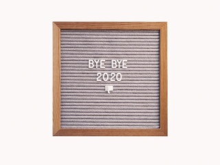 Letter board with words BYE BYE 2020 and nasty gesture. Result of year. Copy space on white background.