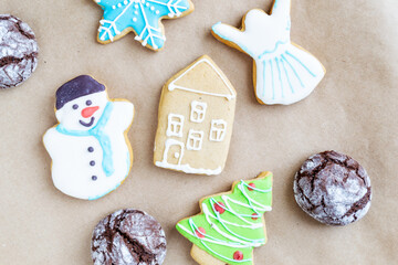 Gingerbread painted colored gingerbread cookies and spices and snowflakes on a craft background close-up. Christmas celebration concept. New Year's food.