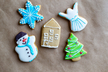 Gingerbread painted colored gingerbread cookies and spices and snowflakes on a craft background close-up. Christmas celebration concept. New Year's food.