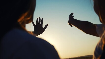 hands in the sun. mom and daughter hands reach out to the sun silhouette sunlight. happy family kid dream concept sunset. mom and daughter dream of god religion concept