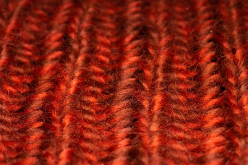 Red-orange knitted background texture. Close-up of knitted stitches. Macro
