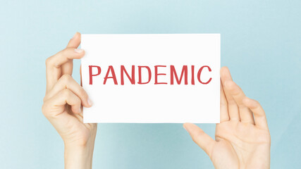 Holding a card with text PANDEMIC. Wuhan Novel Coronavirus pneumonia, Medical concept.