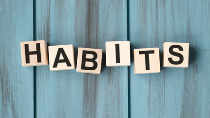 habits - word from wooden blocks with letters, Regular tendency or practice Routine, regularly acts concept, random letters around, top view on wooden background