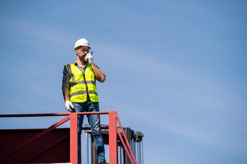 Logistics engineer stand on and Pointing up around Shipping container stacker in commercial transport port