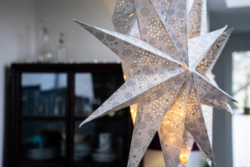 Moderner stylisher Weihnachtsschmuck: Beleuchtete Papiersterne in einem modernen Haus