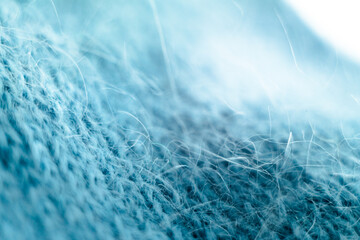 Knitted wool fabric texture background. Soft focus. Macro blur background. Blue woolen hand-knitted