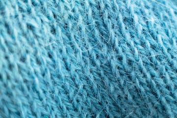 Knitted wool fabric texture background. Soft focus. Macro blur background. Blue woolen hand-knitted