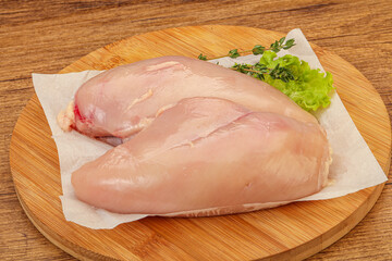 Raw chicken breast over board