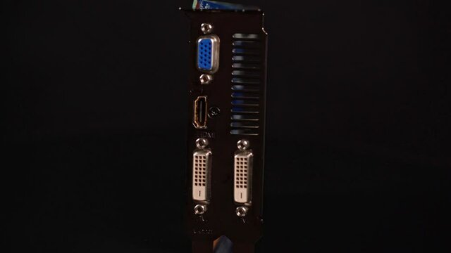 Graphics card for PS platform with two dvi ports, component for video games and cryptocurrency minerization. On a black background in motion.