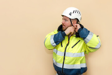 Male industrial worker in winter clothes. Bearded engineer with white hard hat helmet. Climber