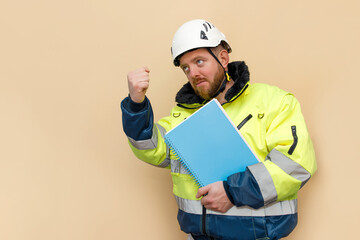 Male bearded industrial worker in hard hat with blue document folder. Man engineer with white hard hat. Climber