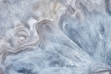 Full-screen close-up texture of light blue-white agate with quartz crystals. Natural stone background.