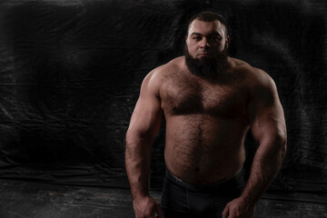 powerful bearded strong man of arab appearance with a naked torso