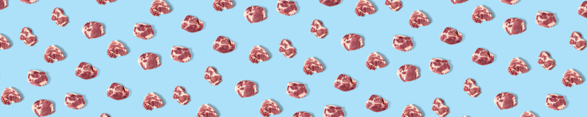 background with raw pork meat slices on blue background, raw food background, not pattern, banner wide shoot