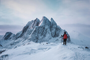 Fototapeta na wymiar Mountaineer woman standing on top of Segla peak with majestic mountain in snowy on winter at Senja