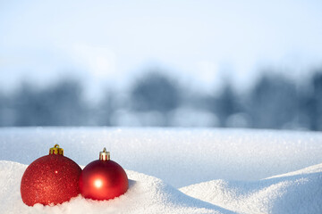 Christmas background with red Christmas ball in the snow