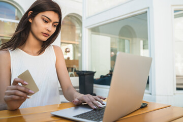 Fototapeta premium Young woman using laptop to shop online.