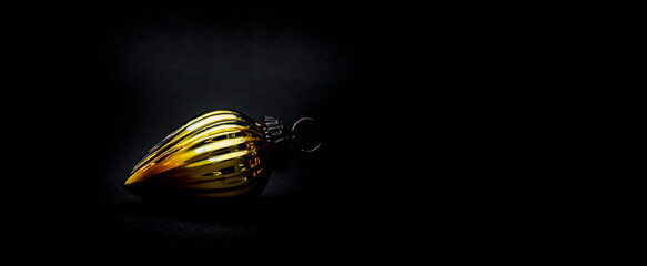 Antike Goldene Weihnachtskugel vor schwarzem Hintergrund