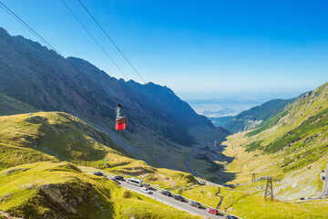 Landscape with Red cable car above the Transfagarasan Alpine Road in summer with Carpathian...