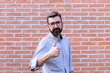 portrait of reliable man with brick wall glasses