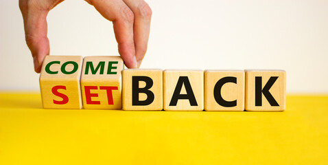 Setback or comeback symbol. Male hand flips wooden cubes and changes the word 'setback' to...