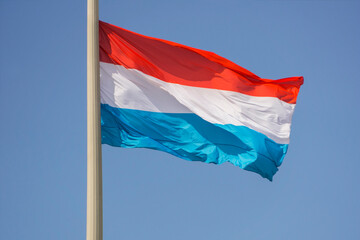 Naklejka na ściany i meble Flag of the Netherlands, close-up, against a cloudless blue sky