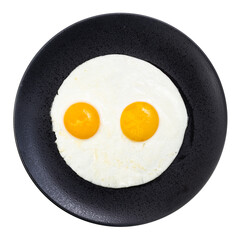 top view of two fried eggs on black plate isolated on white background