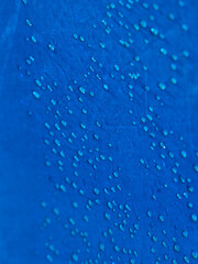 Naklejka na ściany i meble Water drops on waterproof membrane fabric. Detail view of texture of blue synthetic waterproof cloth. Morning dew on tent.