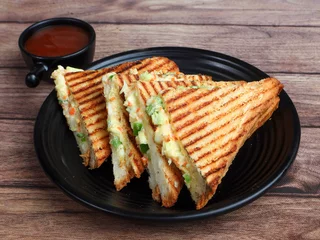 Fototapeten Veg grilled sandwich served with ketchup, isolated over a rustic wooden background, selective focus © Mahi