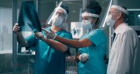 Diverse doctors examining lungs X ray together