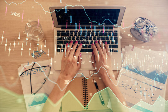 Double exposure of woman hands working on computer and forex graph hologram drawing. Top View. Financial analysis concept. © peshkova