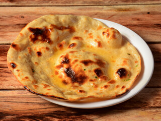 Butter roti, isolated over a rustic wooden background, selective focus