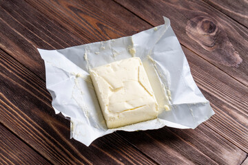 Fototapeta na wymiar butter in an open pack on a wooden background