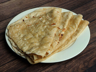 Butter roti, isolated over a rustic wooden background, selective focus