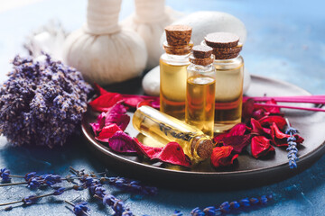 Composition with essential oil bottles and lavender twigs on board