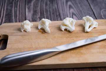Fototapeta na wymiar boiled white cauliflower on a Board and a knife, selective focus, tinted image