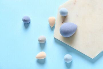 Colorful makeup sponges on color background