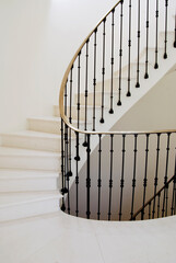 Spiral stone stairwell with brass and iron railing