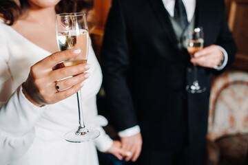 in men's and women's hands champagne glasses