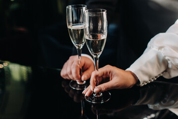 in men's and women's hands champagne glasses