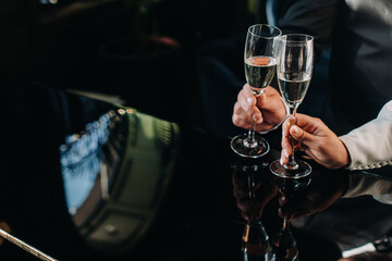 in men's and women's hands champagne glasses