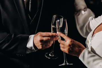 in men's and women's hands champagne glasses