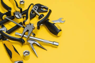 Carpenter tools set on yellow background, top view