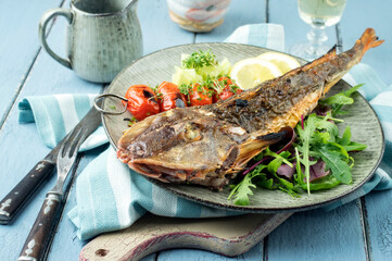 Modern style Atlantic barbecue rose fish with lettuce and tomatoes served as top view on a design plate