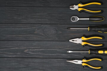 Set of assorted work carpentry and locksmith tools on a dark wooden background with copy space.
