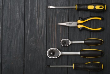 Set of assorted work carpentry and locksmith tools on a dark wooden background with copy space.