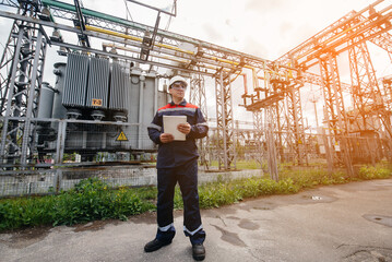 The energy engineer inspects the equipment of the substation. Power engineering. Industry © Andrii